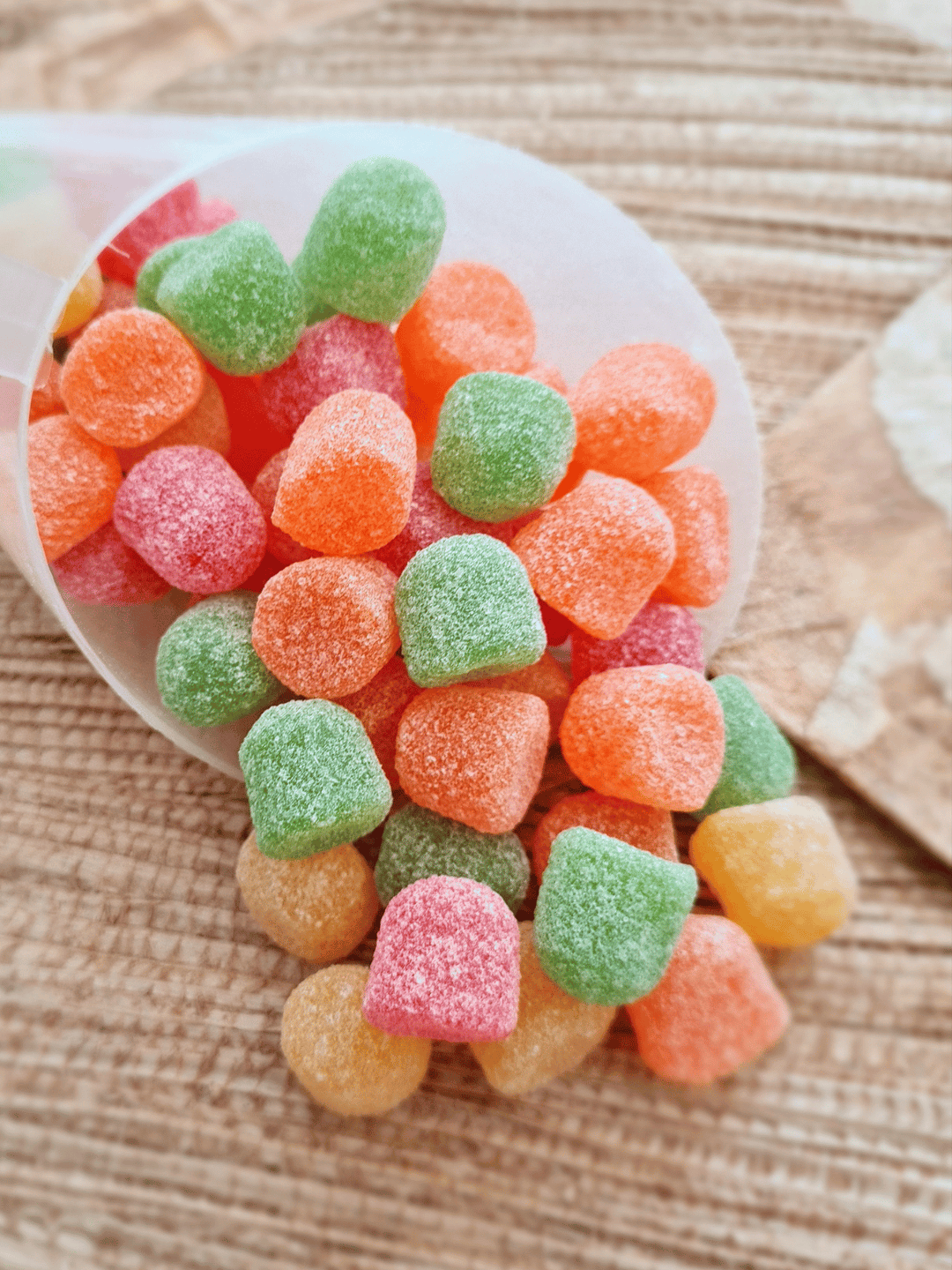 Weingummibeertjes uit een beker op een tafel